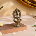 Divine Brass Ganesha Diya with carved Ganesha frame and footed oil bowl on a wooden stand