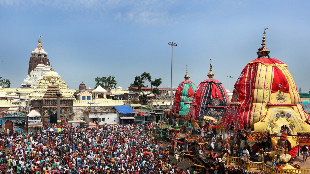 Three towering Rath Yatra chariots stand on the Bada Danda outside the Jagannath temple at Puri, ringed by pilgrims.