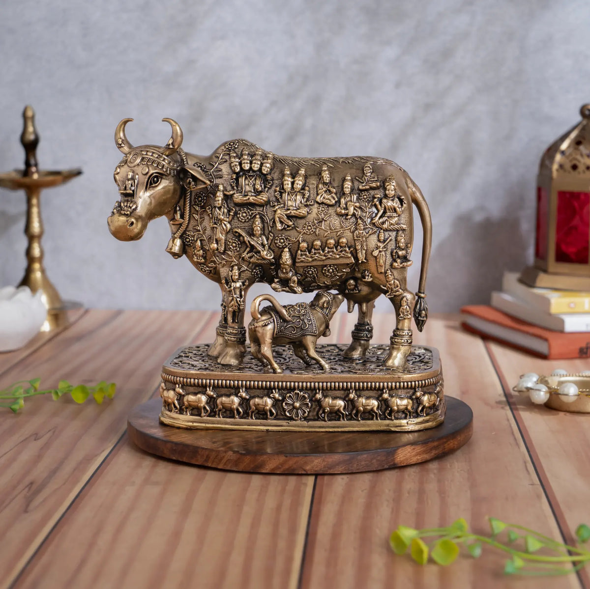 Brass 33 Koti Devi Devta Kamdhenu cow with nursing calf and deity carvings on an ornate brass pedestal