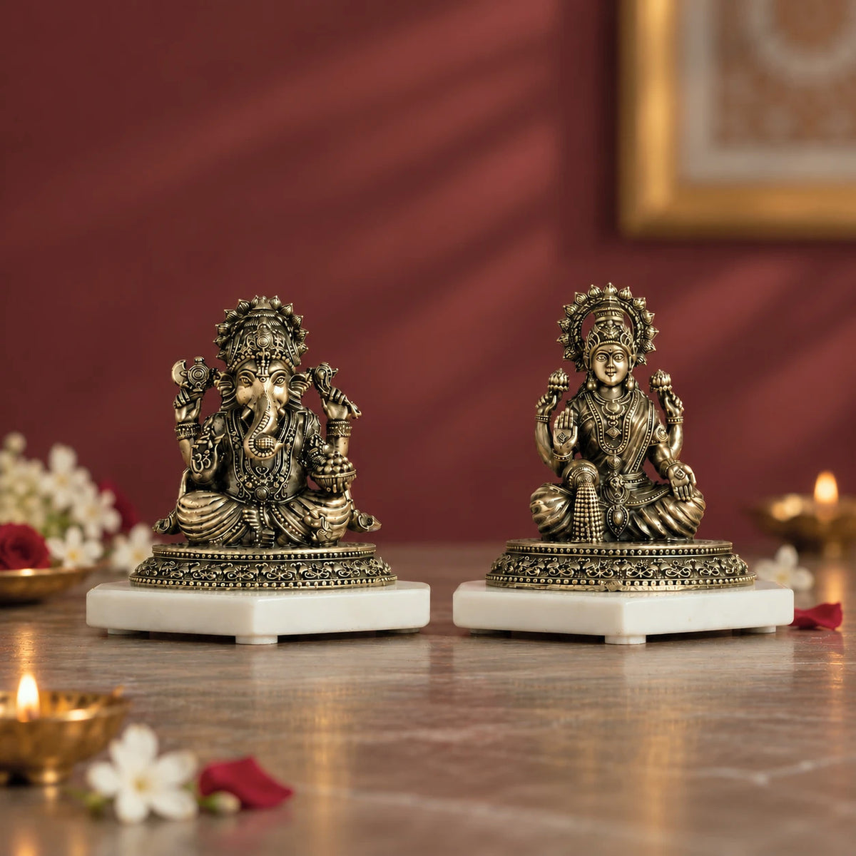 Brass four-armed Lakshmi and Ganesh murti pair, each seated on a white marble base