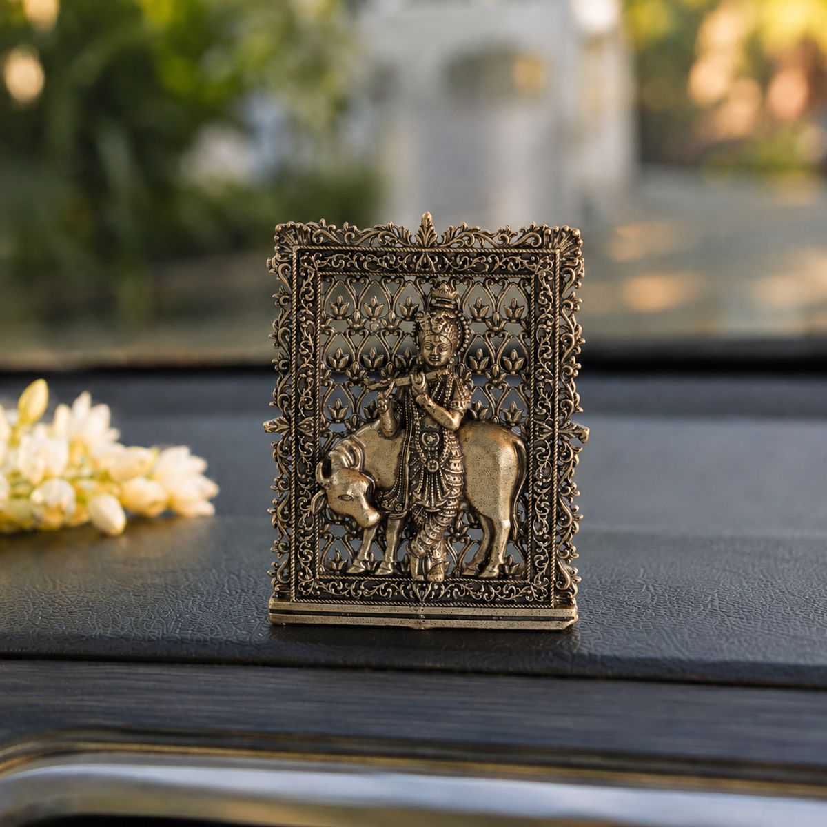 Brass framed Krishna with cow idol for car dashboard, close view