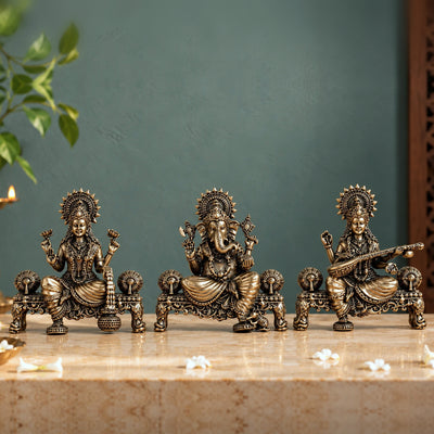 Brass Laxmi, Ganesh and Saraswati murti set, each seated on a carved singhasan