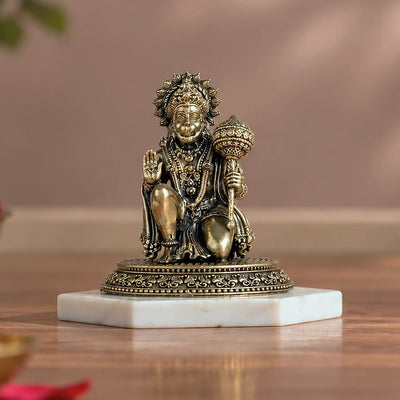 Brass kneeling Hanuman idol with gada, right hand raised in abhaya mudra, on a white marble base