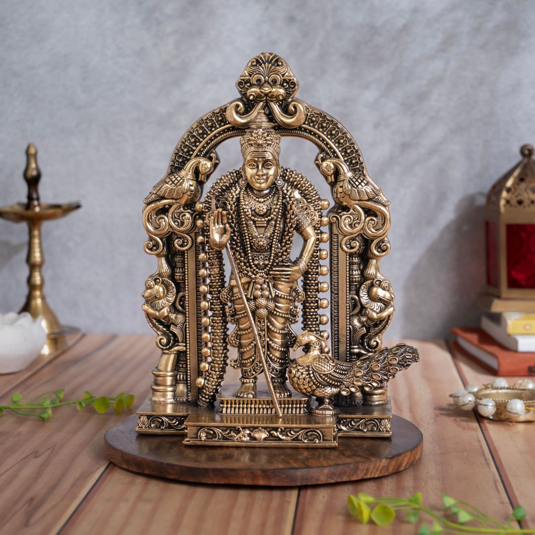 Brass standing Lord Murugan murti with peacock vahana beneath an ornate prabhavali