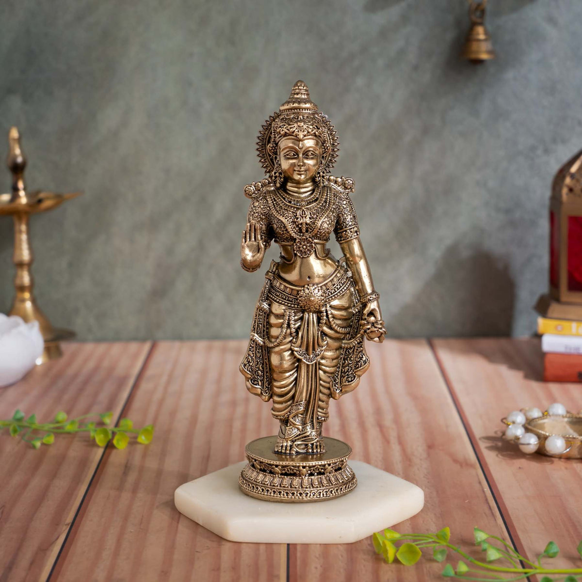 Front view of brass standing Sita Maa idol with her right hand raised in blessing on a carved pedestal